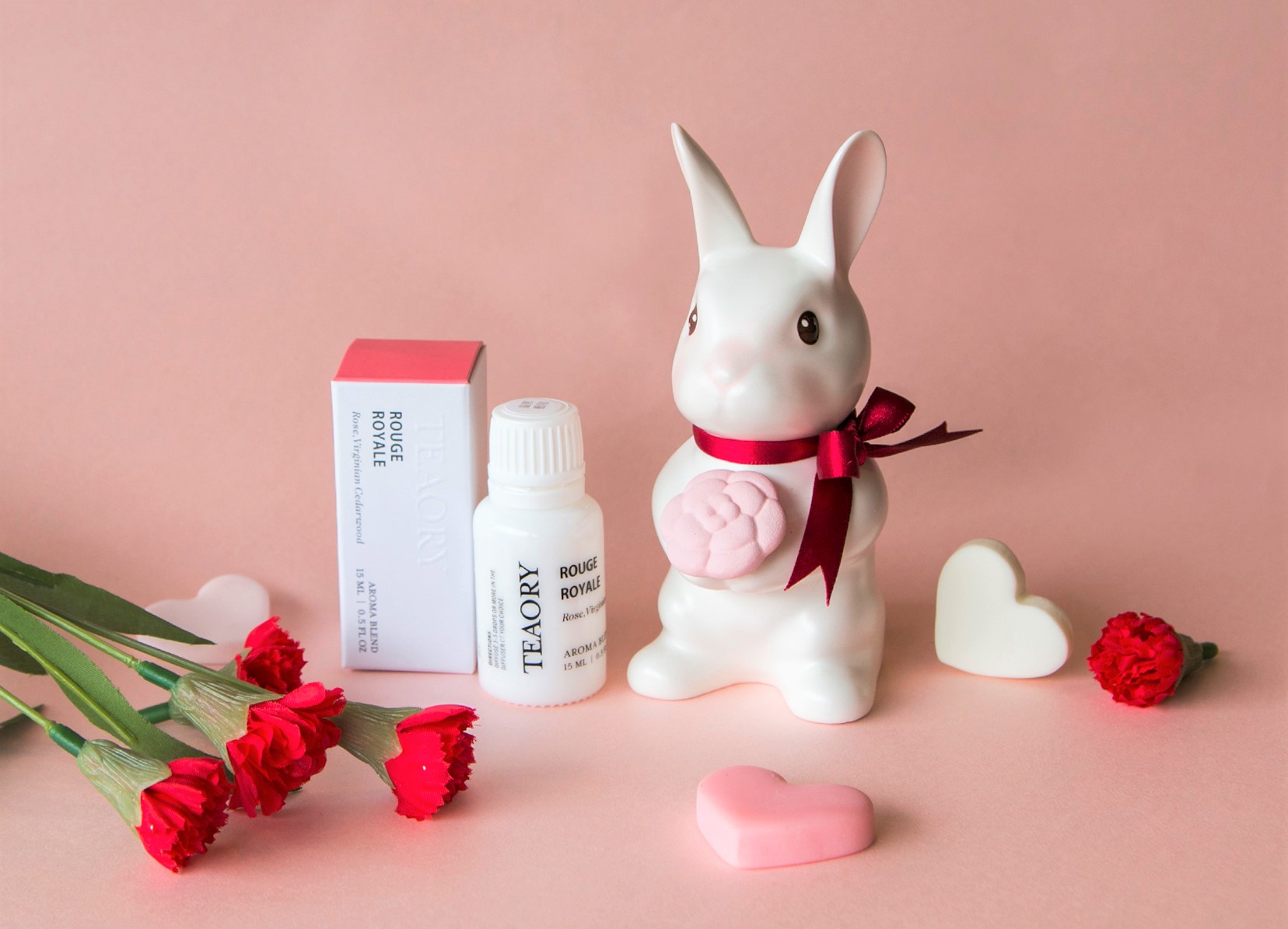 《邦尼先生 Mr. Bunny》雙手捧著綻放的小茶花，表達愛與關懷，是送給媽媽最美好的祝福，搭配「皇家胭脂」複方精華，傳達愉悅香氣及療癒心情。